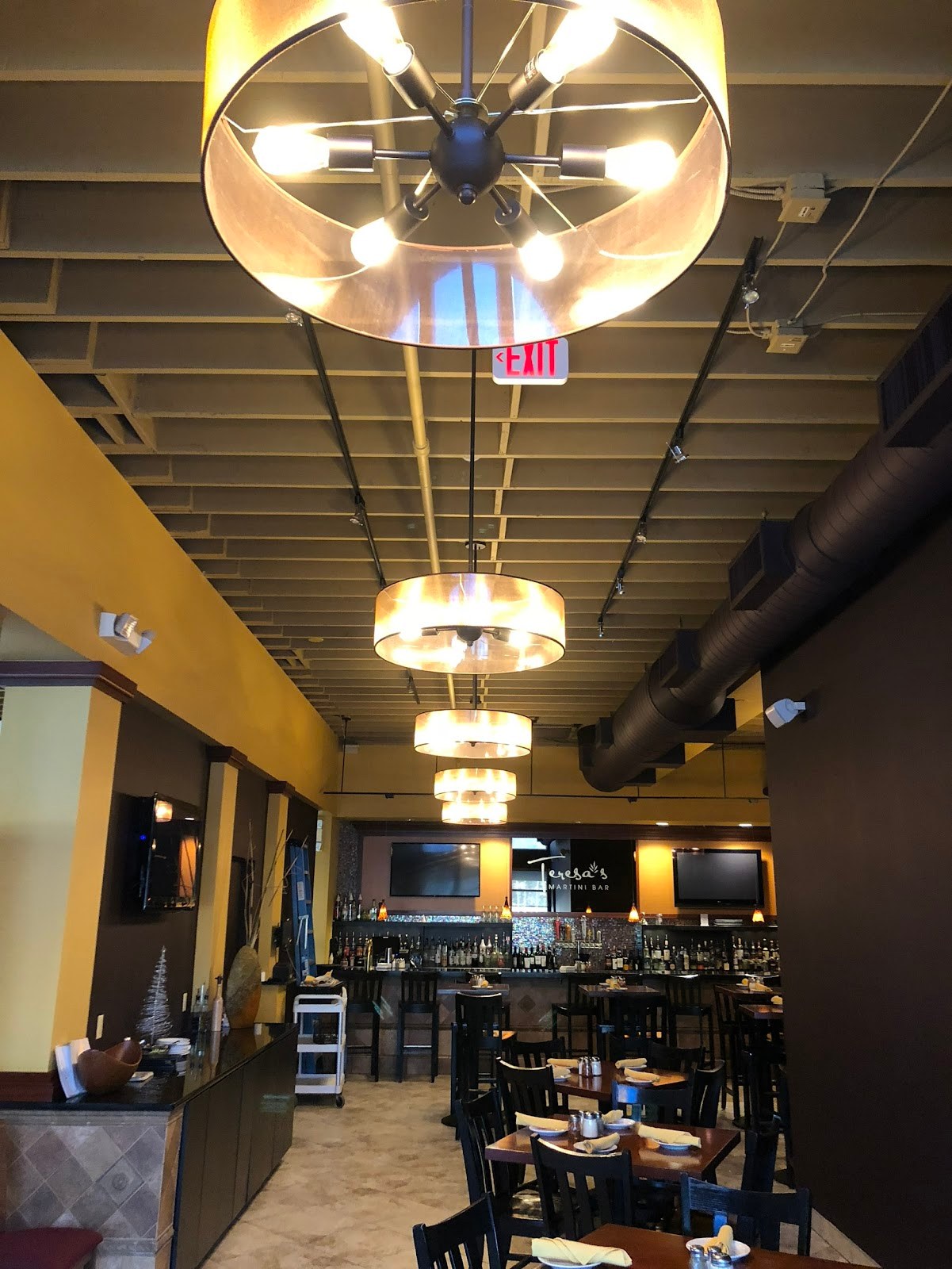 Pendant lighting installed over a restaurant dining room by Almon Electric